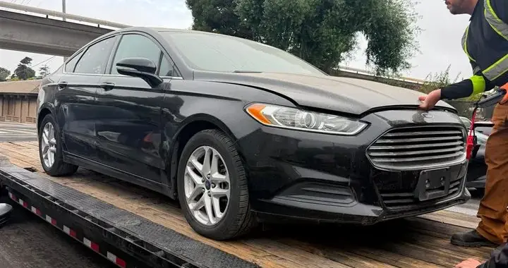 Ford Fusion secured on the transport trailer during delivery